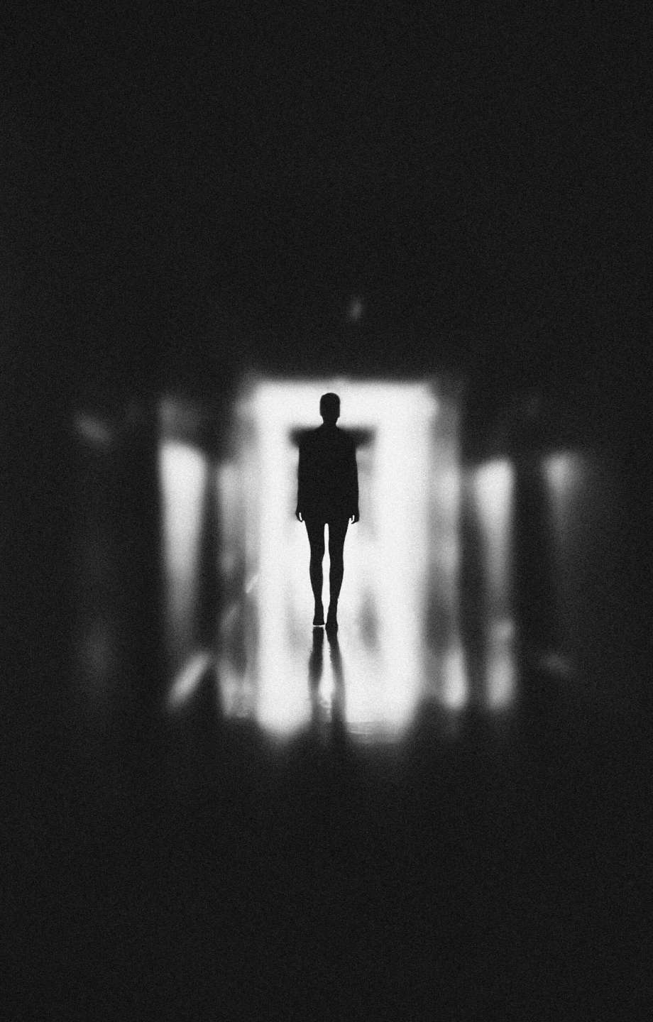 Silhouette of person in a dark hallway